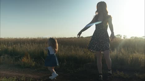 Silhouette-Einer-Glücklichen-Mutter-Und-Tochter,-Die-Draußen-Im-Sommersonnenuntergang-Zusammen-Spielen-Und-Tanzen-Und-Einen-Positiven,-Liebevollen-Moment-Mit-Der-Familie-Oder-Am-Muttertag-In-Filmischer-Zeitlupe-Erleben