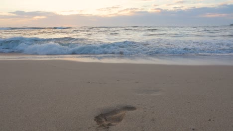 Ein-Einzelner-Fußabdruck-Ist-Im-Sand-Sichtbar,-Wo-Die-Wellen-Während-Eines-Hawaiianischen-Sonnenuntergangs-An-Der-Nordküste-Von-Oahu-Hereinspülen