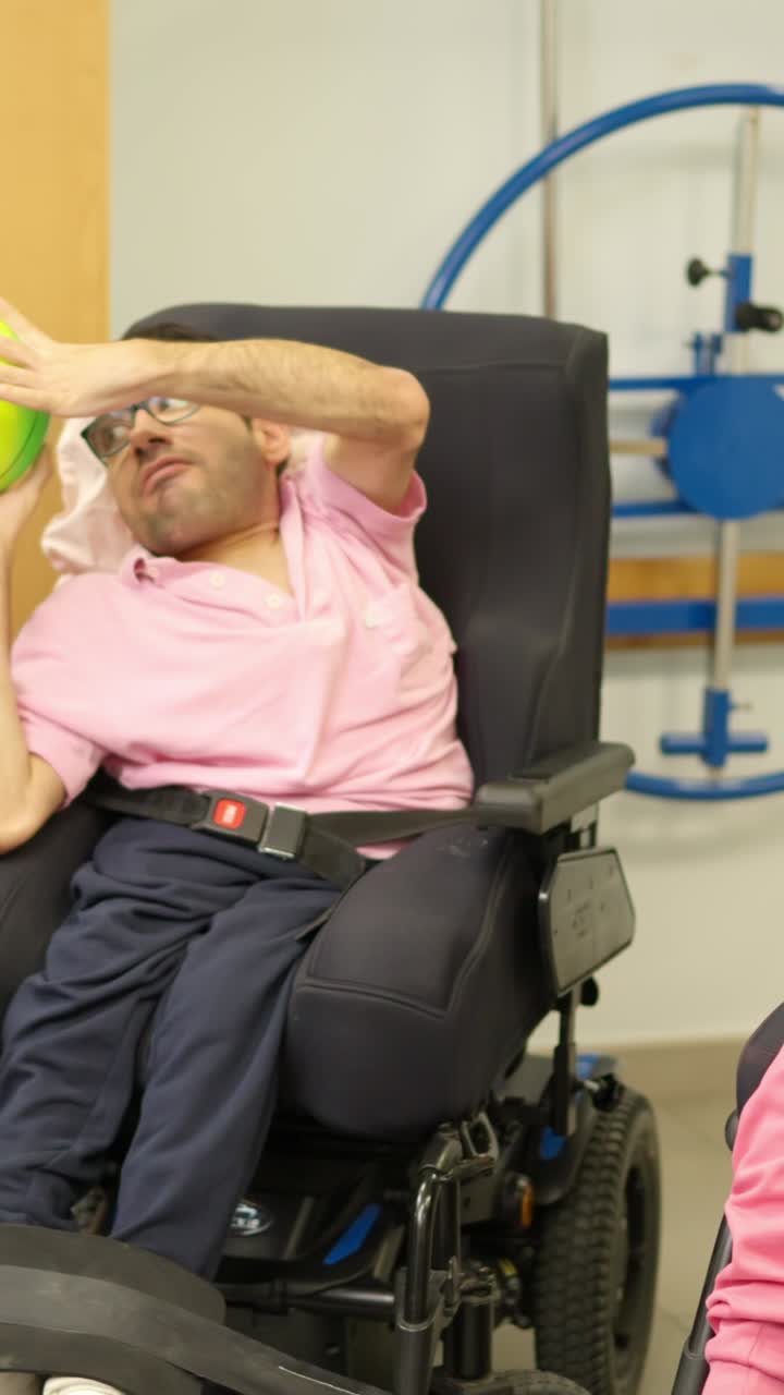 Happy People in Wheelchairs Playing with a Colorful Ball During Therapy