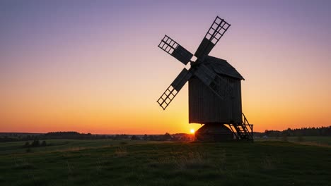 a tranquil sunset over a traditional windmill nestled in rolling fields, capturing the essence of nature's beauty and serene landscapes