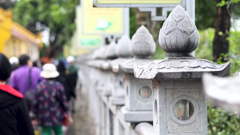 people walking along temple pathway in hanoi