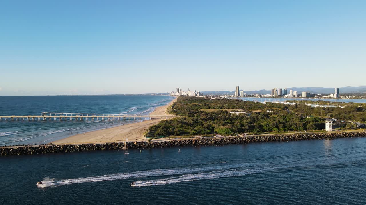 전경에 떠오르는 대도시와 공원이 있는 해양 폐수 배출구 옆의 분주한 운송 채널
