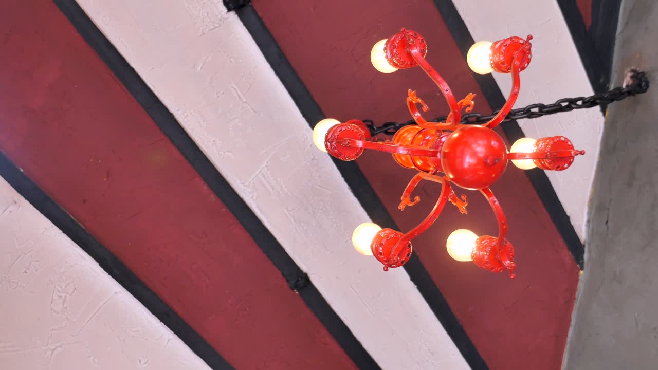 Red Chandelier on Striped Ceiling