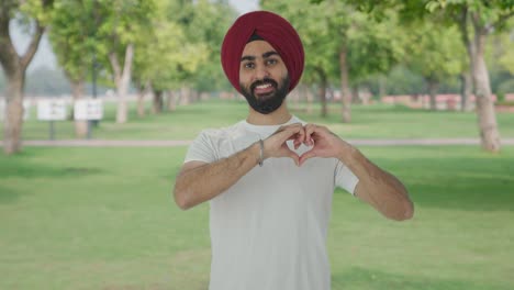 Fröhlicher-Sikh-Indianer-Zeigt-Herzschild-Im-Park