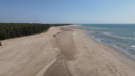toma aérea de drones de playa de arena blanca y agua azul junto a matorrales verdes, darwin, territorio del norte
