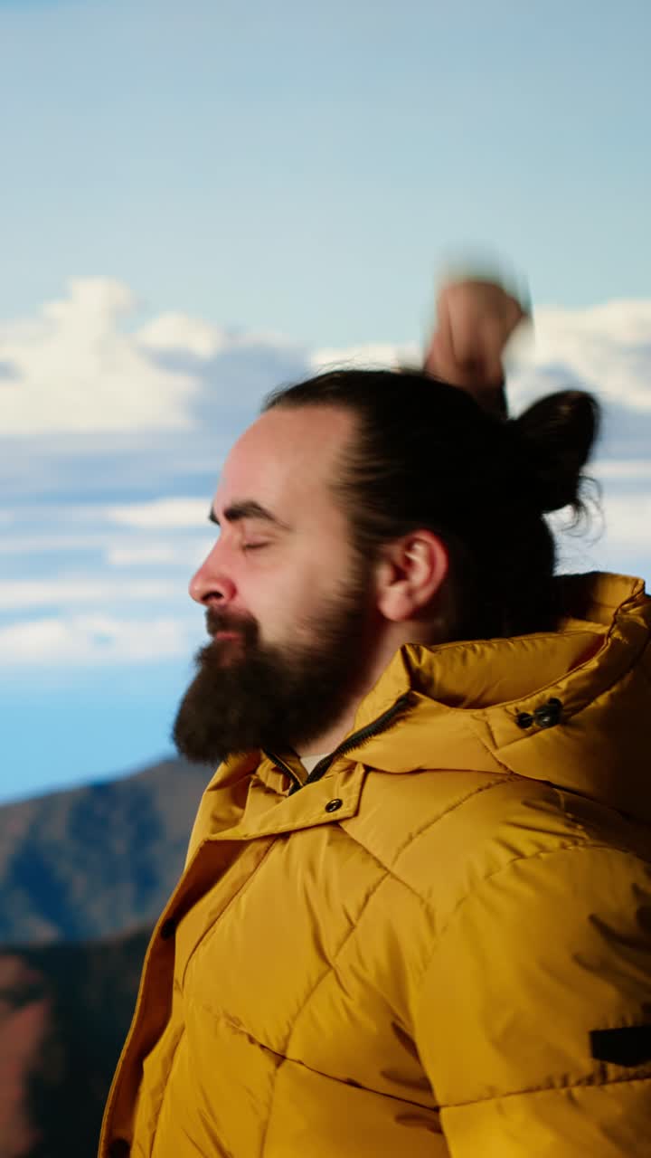 Excited Bearded Man Cheering with Arms Raised in Mountain Landscape