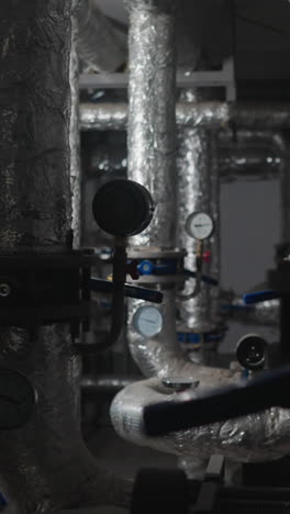 pipes covered with foil thermal insulation to retard heat flow in boiler house. central heating system with connected pipelines in building basement