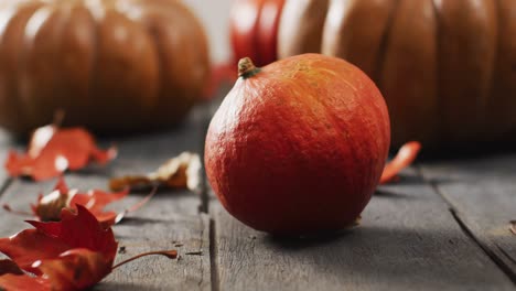 video of pumpkins and autumn leaves on wooden background