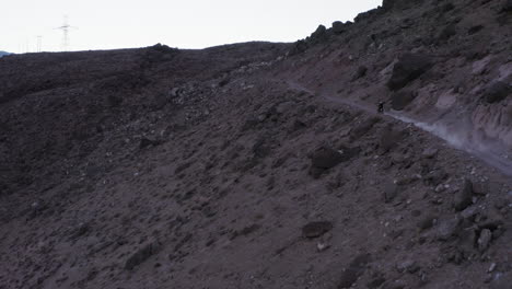 Person-cruising-up-gravel-road-on-dirt-bike