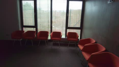 empty orange chairs in hospital. hospital passage and waiting area with empty seats.