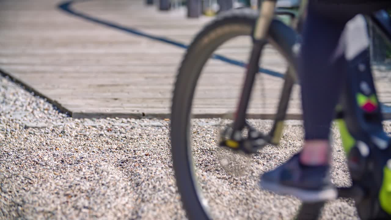 Low angle view of bicycle wheels, couple cycling wood pathway. Leisure activity