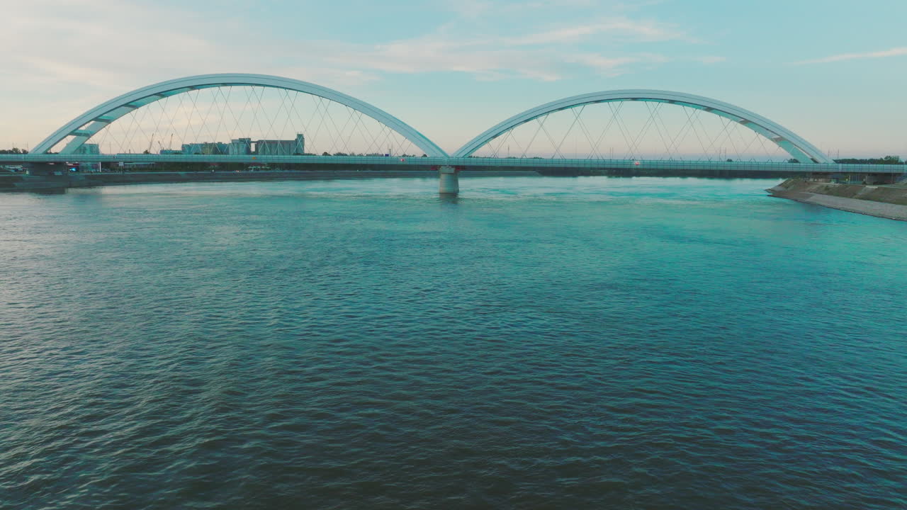 새벽/일몰 에 강 을 가로지르는 현대적 인 아치 다리