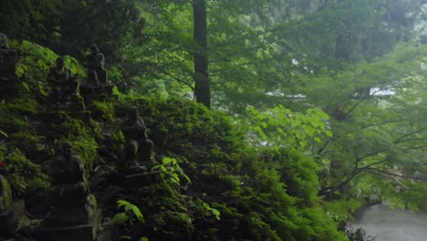 jizo and buddha daibutsu stone statues at top of mountain forest of nanzoin temple fukuoka japan rainy day panning