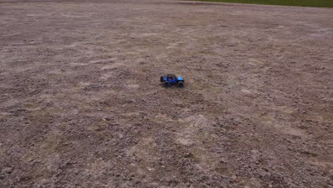 a miniature electric 4wd vehicle races over a rough terrain, leading the way for an outdoor competition