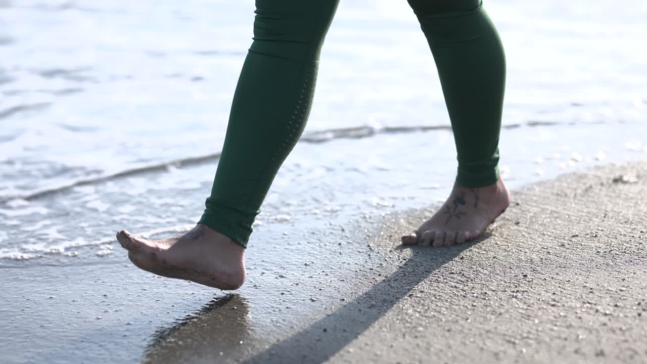 Woman walking barefoot on the beach