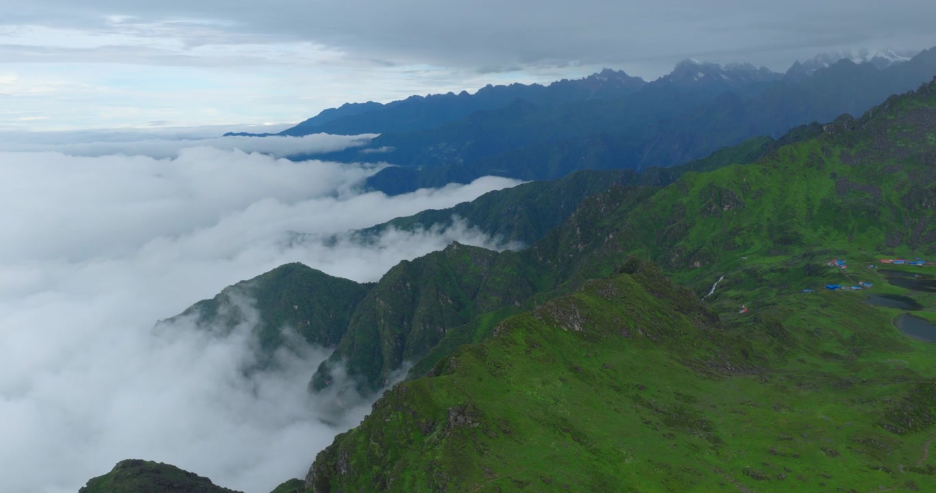 Vista aérea das vibrantes cristas verdes das montanhas do Himalaia flutuando acima de uma camada de nuvens baixas de monções e nevoeiro denso na cênica região de Panchpokhari, Sindhupalchowk, Nepal