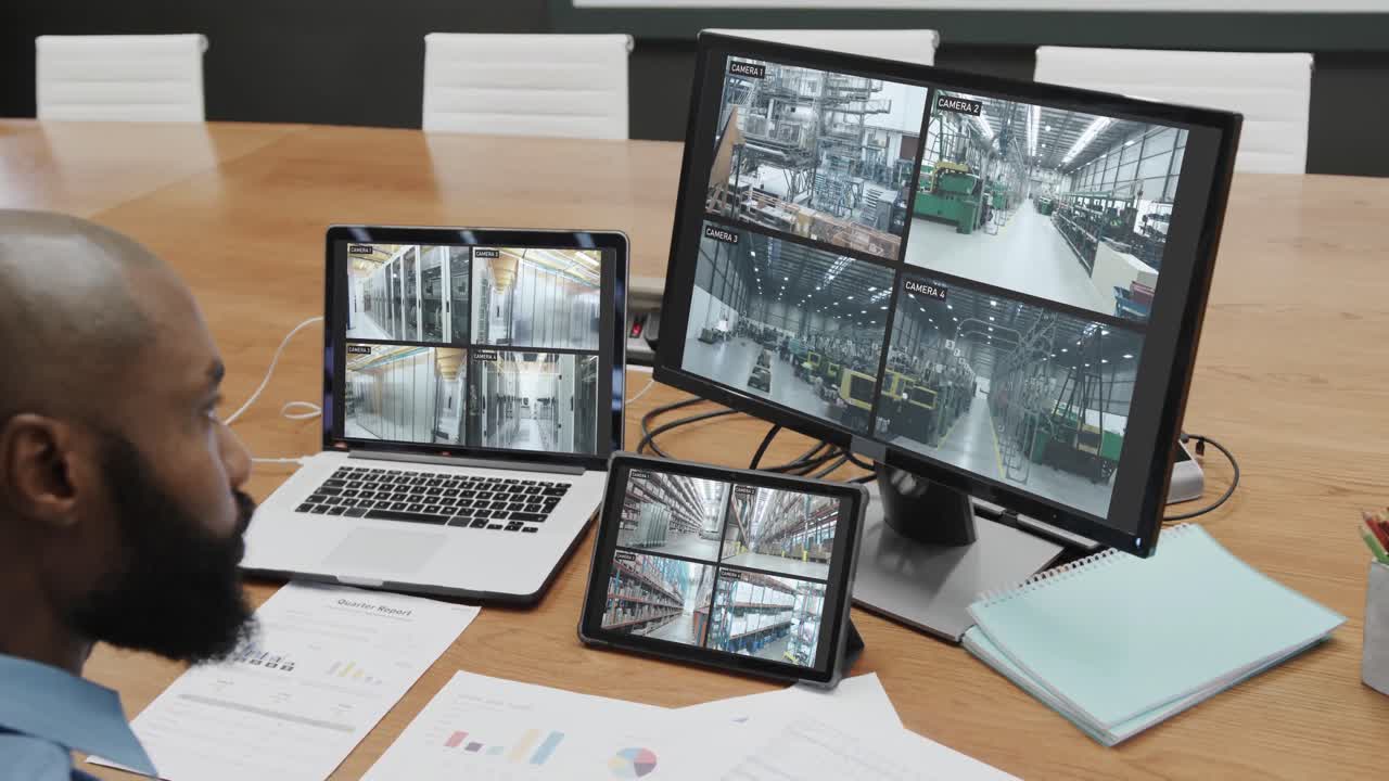 oficial de seguridad afroamericano viendo las vistas de las cámaras de cctv en pantallas de computadora, cámara lenta