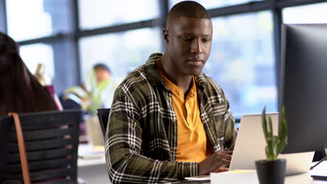 African-american-businessman-using-computer-in-office,-slow-motion,-copy-space