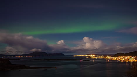 time lapse, aurora borealis polar lights above clouds and bay of valderoy island norway