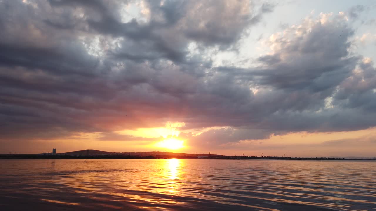 Coucher de soleil sur la mer calme. Paysage nuageux spectaculaire. Des insectes volent dans le ciel. La lumière du soleil se reflète sur la surface de la mer. Coucher de soleil sur la mer Noire, Bulgarie
