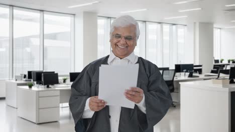 un abogado indio feliz leyendo los papeles del caso de la corte.