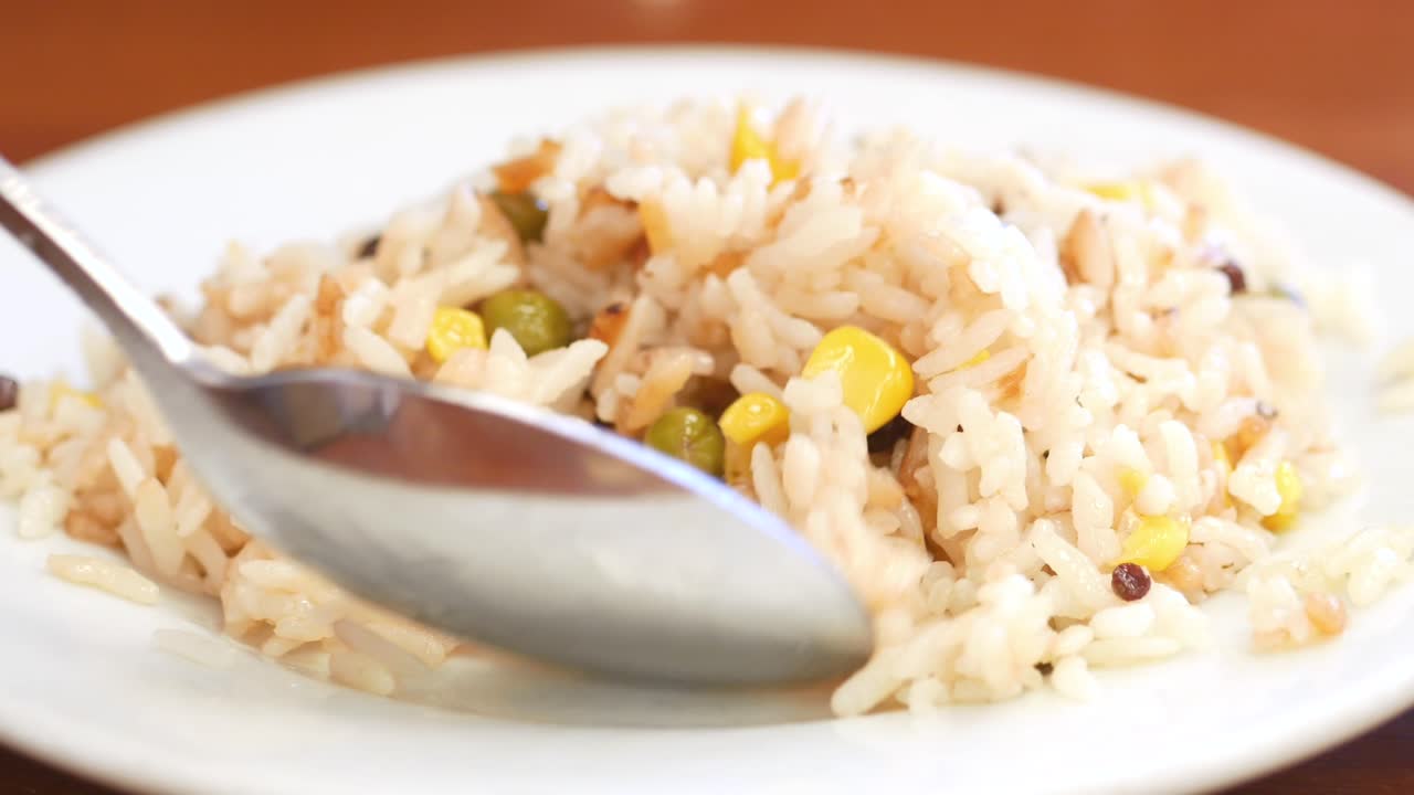 cerca de un plato de arroz blanco con guisantes y maíz