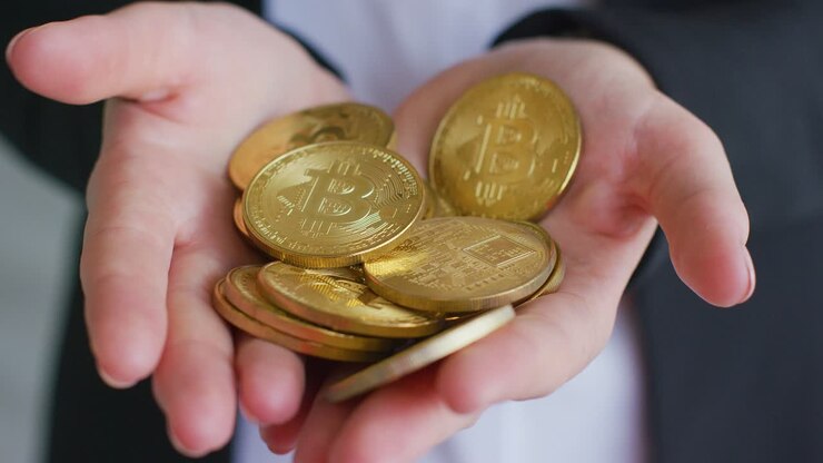 Donna con giacca formale nera che tiene in mano una manciata di bitcoin lucidi