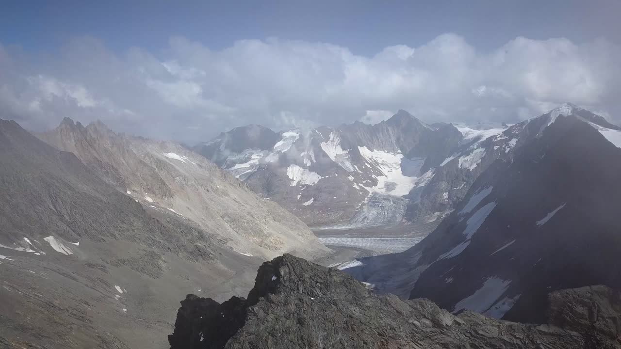 toma aérea de descubrimiento de un valle en los alpes suizos y un pico afilado en un día de verano con nubes