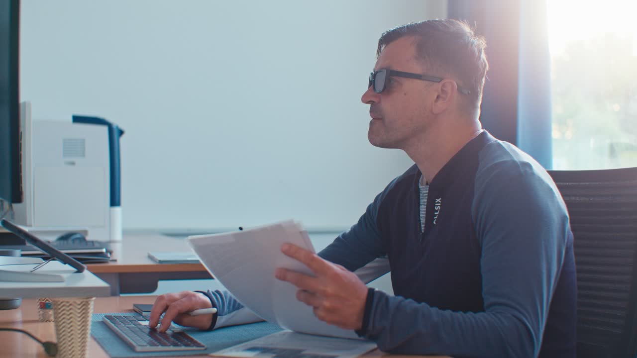 Busy European Dutch Caucasian white man male adult model with glasses working in the office job on desktop workspace with paper documents and PC, digital film look