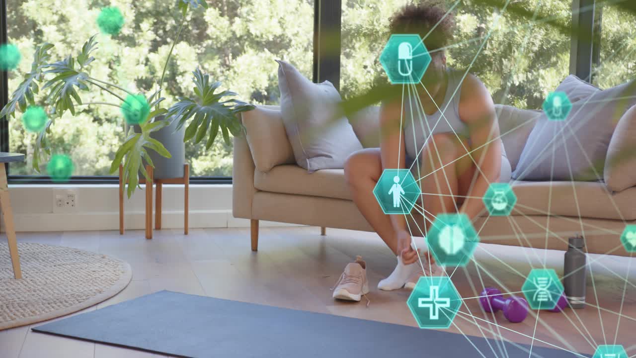 Woman preparing workout on sofa reaching for sneaker, tying laces while fitness overlay appearing