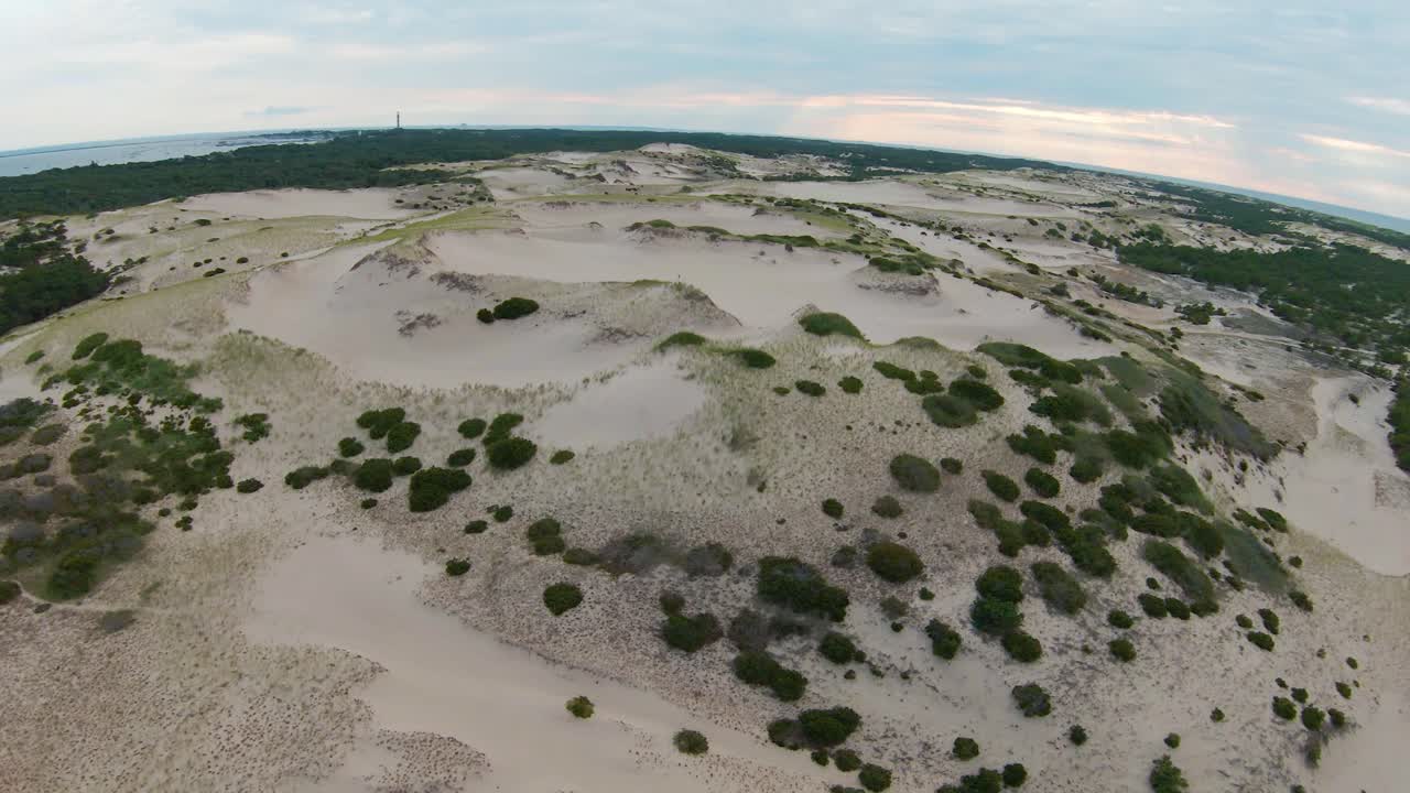 un dron a vista de pájaro del increíble paisaje y siguiendo a una niña corriendo en las altas dunas de arena y senderos en el sendero dune shacks en provincia, cape cod, massachusetts