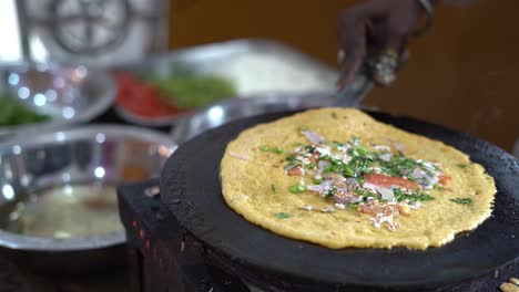 closeup slow motion shot of making steaming hot 'dosa' on a cast iron pan at a hotel