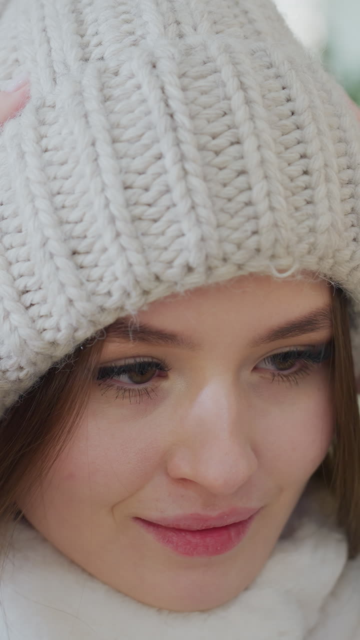 Close-up of woman in soft, fluffy winter jacket adjusting her head warmer with a blurred background of people seated around, cozy and stylish winter fashion moment