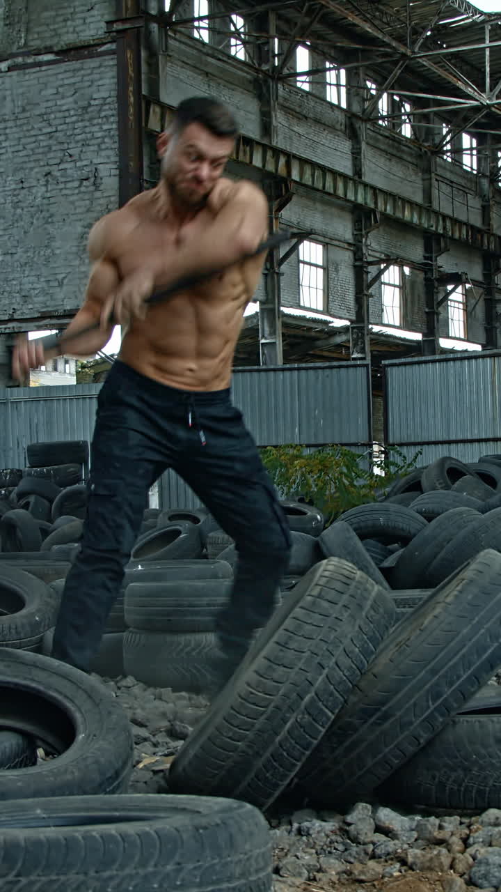 Man train with hammer and tires. Strong muscular man with perfect body training with big sledgehammer