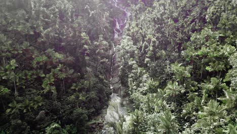 Waterfall-with-exposed-rock-faces-in-dense-green-Caribbean-forest