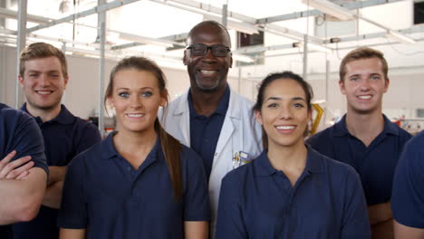 portrait of engineer with apprentice students in workshop