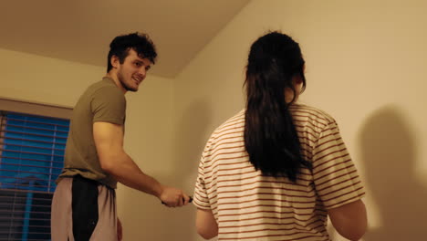 Playful-white-couple-having-fun-with-each-other-while-painting-a-wall-white