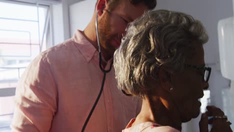 doctor examining a senior woman in a retirement home