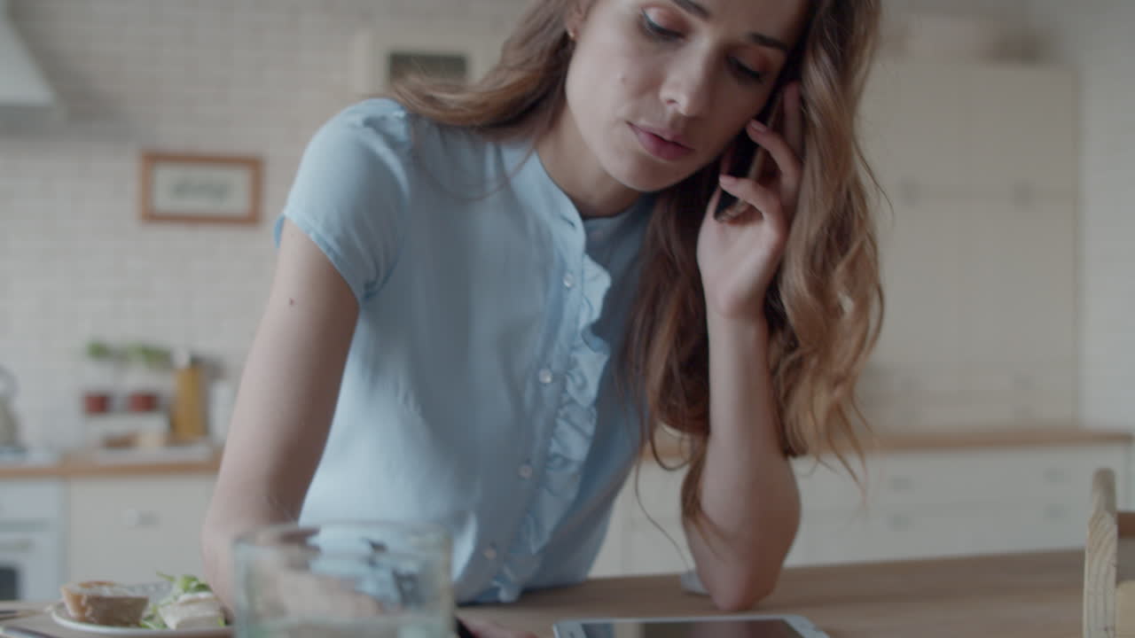 Young businesswoman making notes at home kitchen