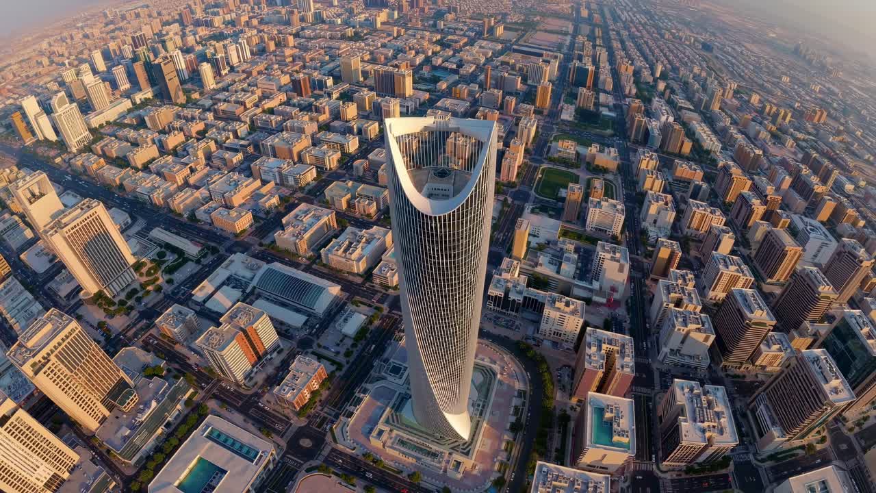Luftaufnahme eines futuristischen Wolkenkratzers in einem weitläufigen Stadtbild bei Sonnenuntergang, der urbane Elemente zur Schau stellt