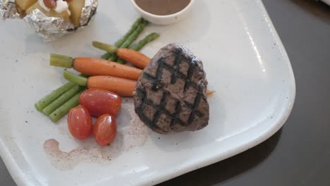 panning view of a dish with roasted tenderloin beef with organic vegetable