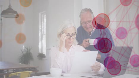 animation of media icons over senior caucasian couple using laptop