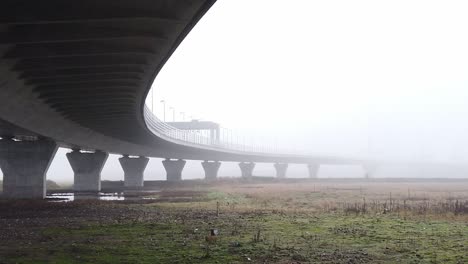 ghostly misty concrete support structure under motorway flyover right pan