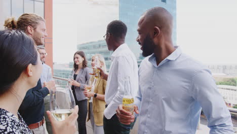 Colegas-De-Negocios-Celebrando-Con-Bebidas-En-Un-Balcón-De-La-Ciudad-Después-Del-Trabajo,-De-Cerca