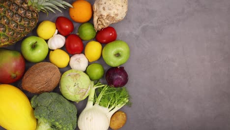 interesante composición de frutas y verduras maduras frescas se mueven en el lado izquierdo del fondo oscuro. detener el movimiento