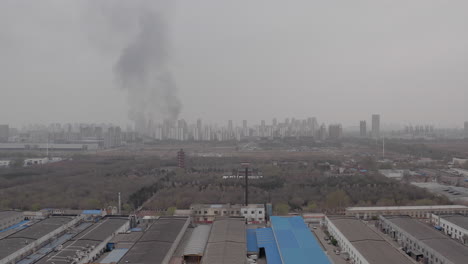 huge plumes of smoke are visible on the horizon near the industrial zone in tianjin, china