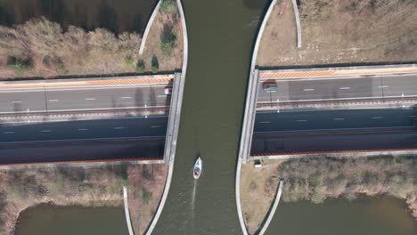 Aerial-Topdown-of-Boat-Crossing-Waterbridge-with-Automobile-Traffic-Underneath-in-Veluwemeer,-Netherlands