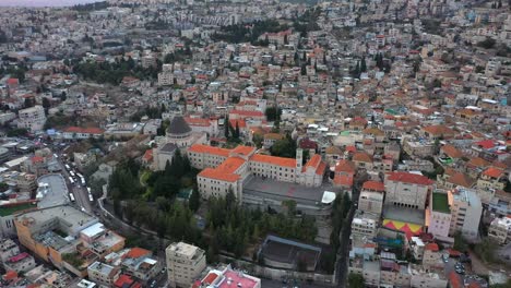 aerial footage of the basilica of the annunciation over the old city houses of nazareth