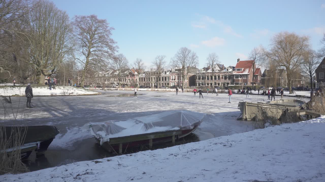 구시가지의 얼어붙은 강에서 스케이트를 타는 네덜란드 현지인, 전통적인 겨울 장면