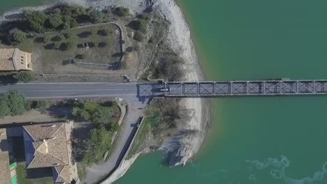 Top-aerial-view-of-car-driving-on-bridge-in-Vasco-region-coastline,-dolly-right